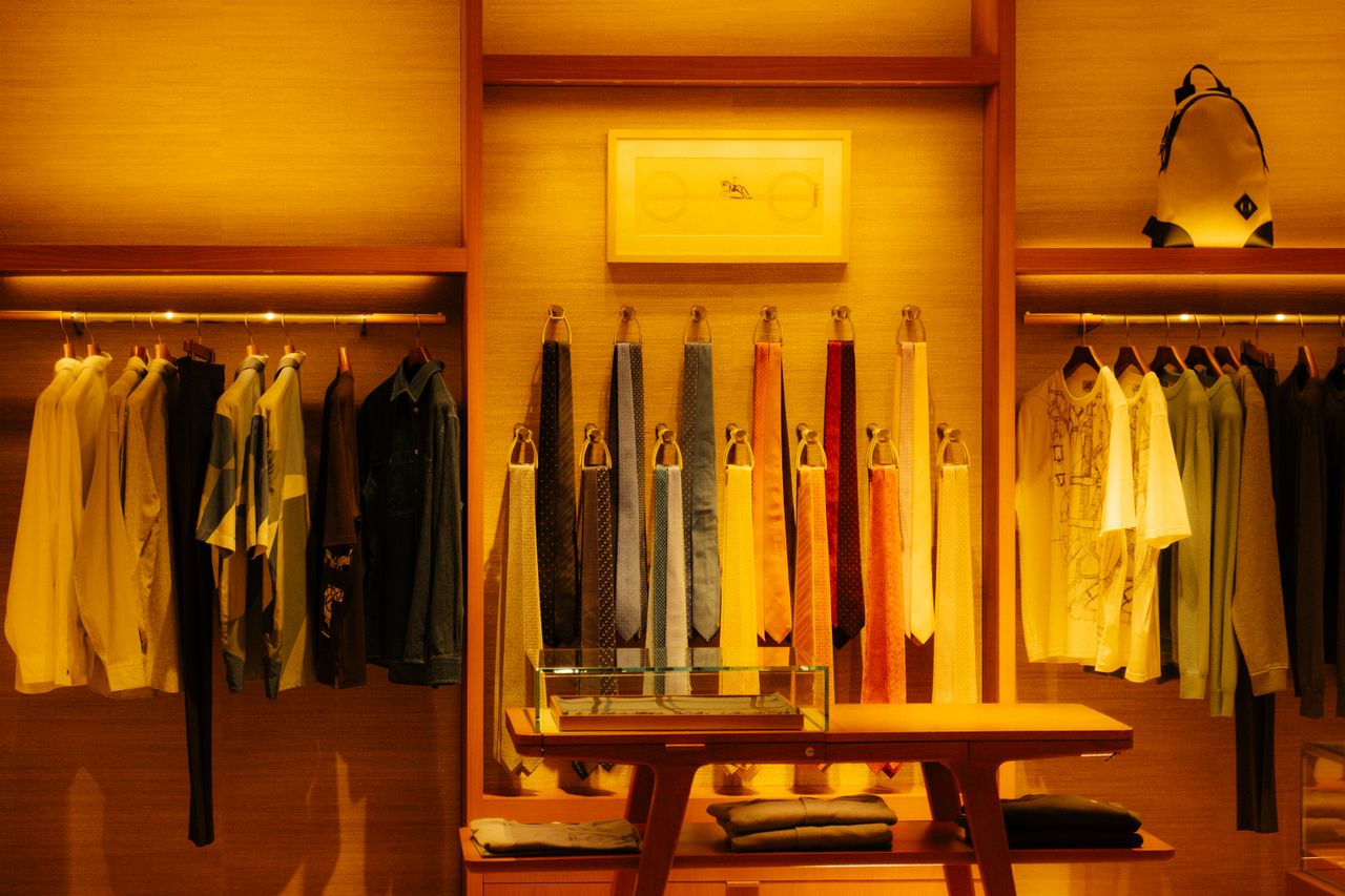 creative-02 Stylish fashion store interior showcasing clothes and accessories under warm lighting.