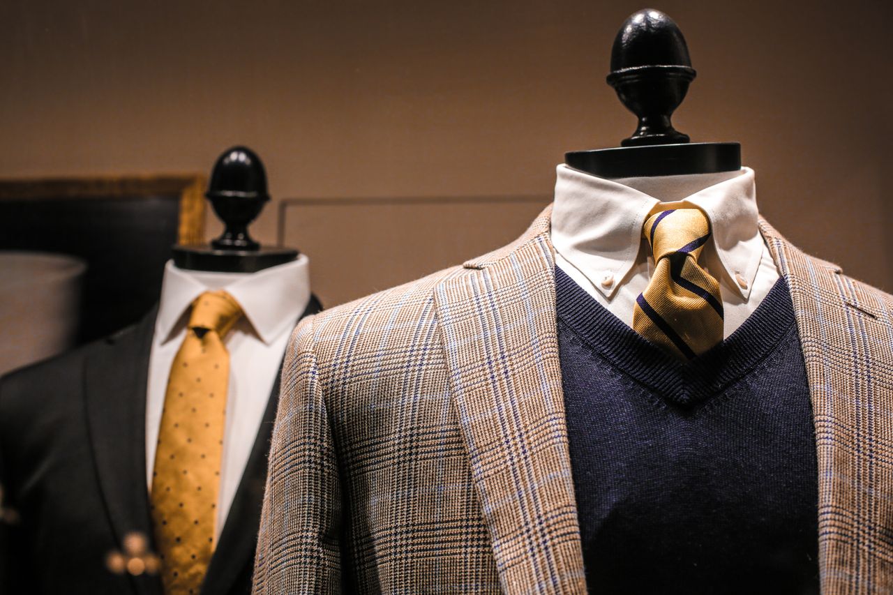 creative Dandy fancy jackets with shiny ties on dummies in showroom of contemporary male shop